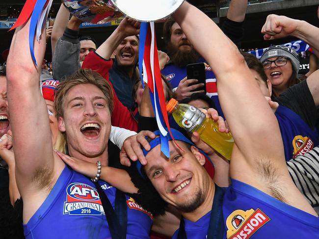 MELBOURNE, AUSTRALIA - OCTOBER 01:  Shane Biggs and Clay Smith of the Bulldogs  celebrates with the trophy after winning the 2016 AFL Grand Final match between the Sydney Swans and the Western Bulldogs at Melbourne Cricket Ground on October 1, 2016 in Melbourne, Australia.  (Photo by Quinn Rooney/Getty Images)