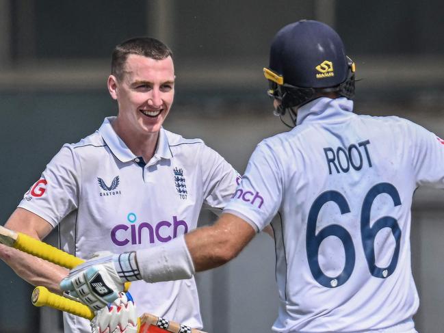 England's Harry Brook (L) celebrates with teammate Joe Root after scoring a double century (200 runs) during the fourth day of the first Test cricket match between Pakistan and England at the Multan Cricket Stadium in Multan on October 10, 2024. (Photo by Aamir QURESHI / AFP)