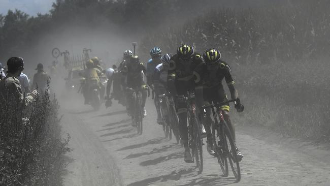 A nine-men breakaway rides in a cloud of dust on a cobblestone section of the ninth stage. Picture: AP