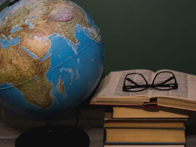 Old school books on a desk with a globe in front of a green chalkboard Picture: iStock.