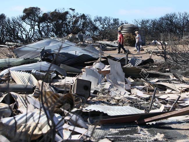 Glenda Wilby and Brently Golder amid the utter destruction on their beach shack in Hanson Bay. Picture: Emma Brasier