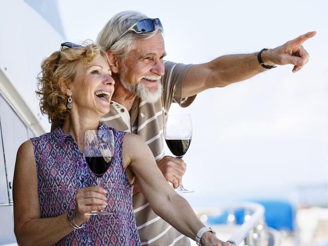 Happy senior couple enjoying wine on yacht. seniors and retirees travel, holidays, generic