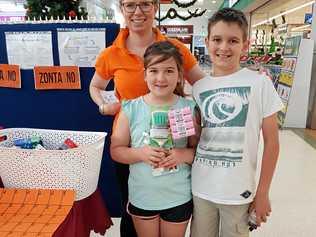 SPIRIT OF GIVING: Violet and Harry Humphreys donate care items to Zonta's Megan Devlin.