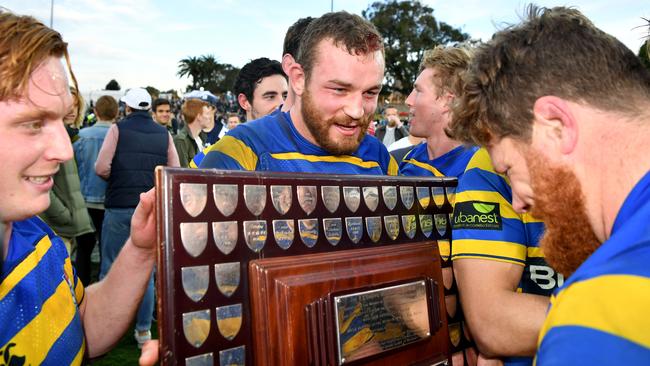 Rohan O'Regan of Sydney University celebrates victory with the shield.