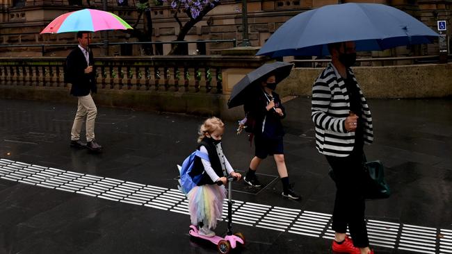 Walking through the streets of a soggy Sydney on Friday. Picture: NCA NewsWire / Jeremy Piper