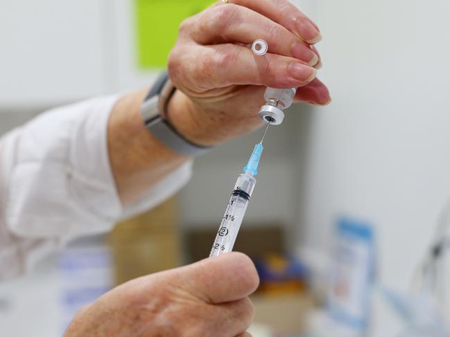 SYDNEY, AUSTRALIA - MARCH 23: Nurse Catherine Guy handles a COVID-19 AstraZeneca vaccine vial at the Sydney Road Family Medical Practice on March 23, 2021 in Sydney, Australia. Medical practices across Australia have started COVID-19 vaccinations for eligible Australians under the Phase 1b rollout. (Photo by Lisa Maree Williams/Getty Images)