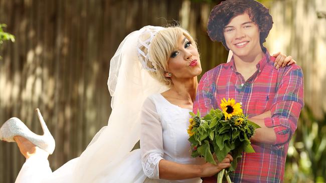 Single woman Janey Birks, who is set to appear on Bachelor in Paradise, in her wedding dress with her cardboard cut-out of Harry Styles. Picture: Liam Kidston.