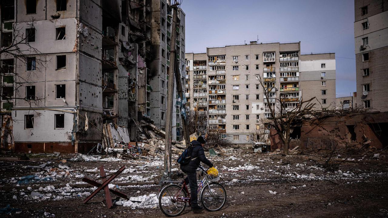 A man rides his bicycle in front of damaged residential buildings in the city of Chernihiv. Picture: Dimitar Dilkoff/AFP)