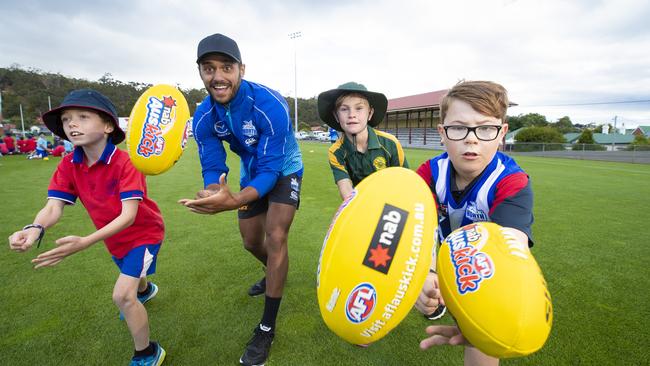 Tassie Kangaroo Aaron Hall with Jasper Delaney, 8, of Sacred Heart College, Poppy Wilson, 9, of New Town Primary School, and Oscar Ladd, 9, of Immaculate Heart of Mary Catholic School, during North Melbourne’s AFL Community Camp at North Hobart Oval. Picture: RICHARD JUPE