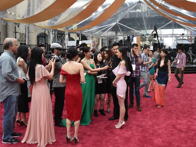 Journalists interview Chinese actress Huang Shengyi on the red carpet outside the Dolby Theatre.