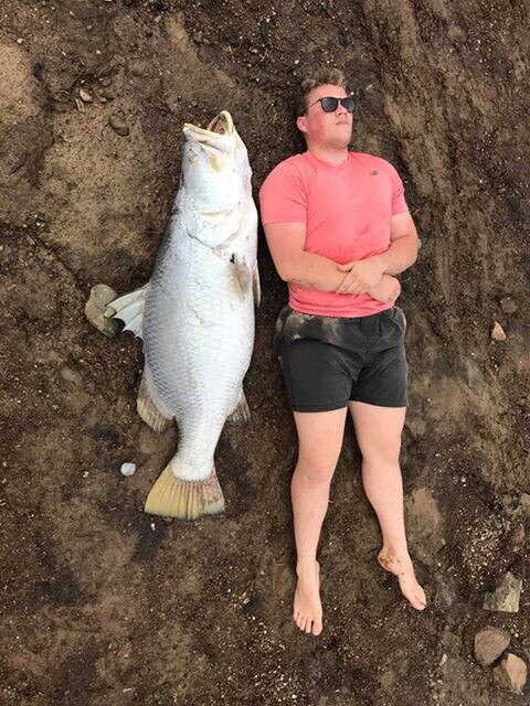 Jesse Bradford with the enormous barramundi he and his friend Dylan Cosgrove found at Kinchent Dam.