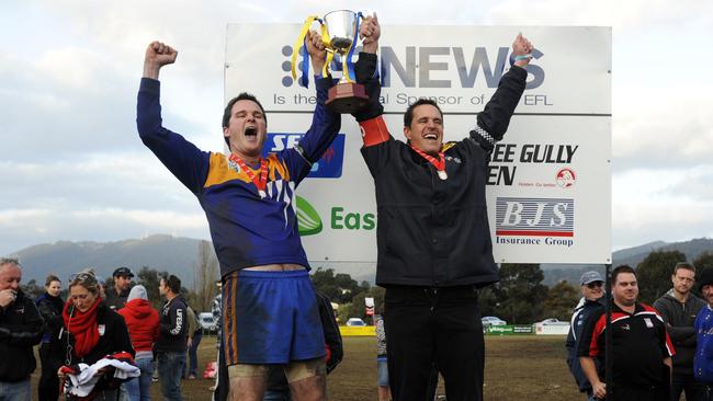 Buckle (right) lifts the 2011 Division 4 cup as Heathmont coach following an extra-time win in the grand final.