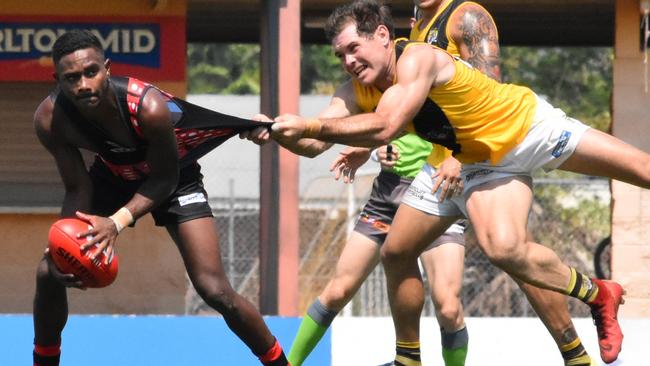 Jeffrey Simon gets set to fire out a handpass despite the close attention of Nightcliff's Brodie Filo. Picture: Tymunna Clements, AFLNT Media.