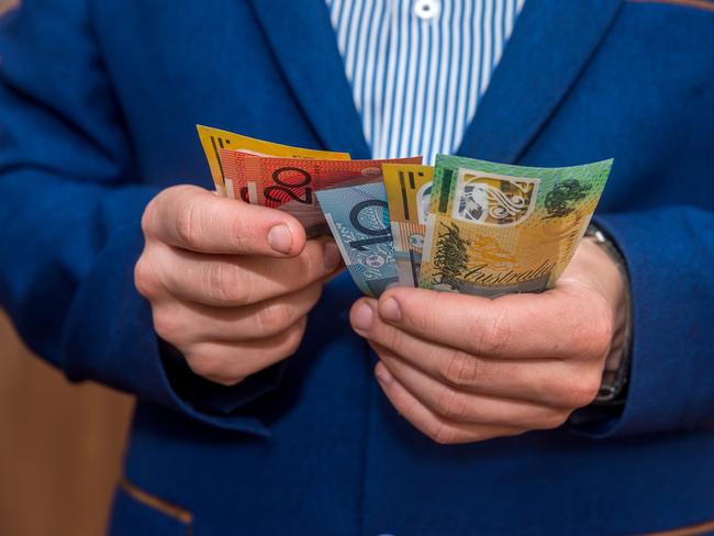 Male hands holding australias dollar banknotes closeup