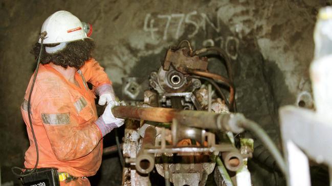 A diamond driller offsider prepares the machine to take another core sample for the geologists to map.