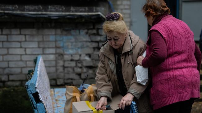 A woman opens an emergency food package this month in Svyatohirsk, Donetsk oblast, Ukraine.