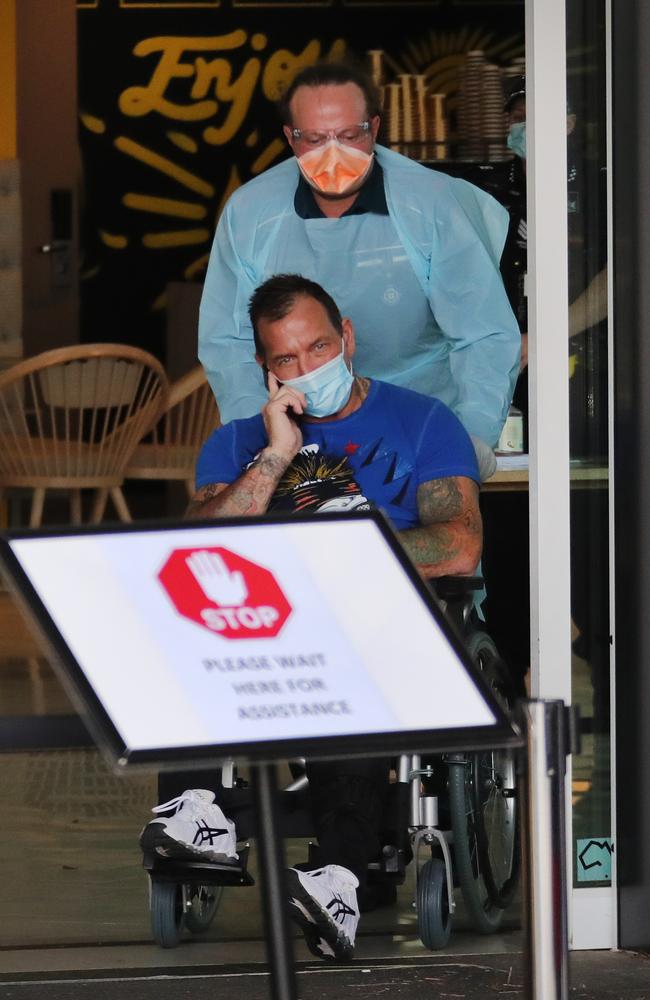 Shane Bowden is taken in a wheelchair from a Gold Coast quarantine hotel to Gold Coast University Hospital. Picture: Glenn Hampson.