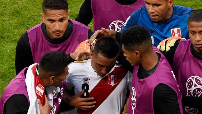 Peru midfielder Christian Cueva (centre) is comforted by team-mates at half-time after his missed penalty against Denmark. Photo: AFP