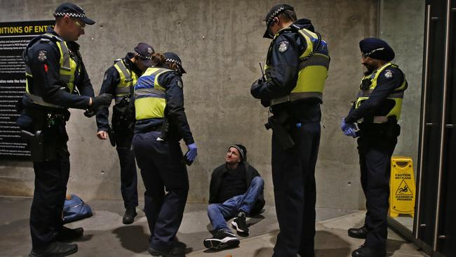 Police officers question a fan. Picture: David Caird