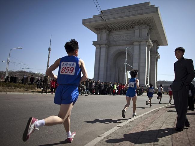 Triumph awaits ... people watch runners near the Arch of Triumph in Pyongyang during the 26th Mangyongdae Prize Marathon.