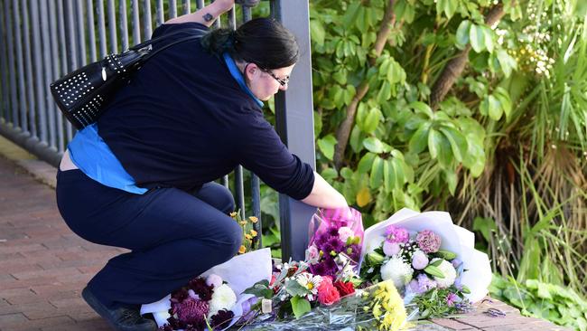 A woman lays flowers at the site where the murder occurred. Picture: Bianca De Marchi