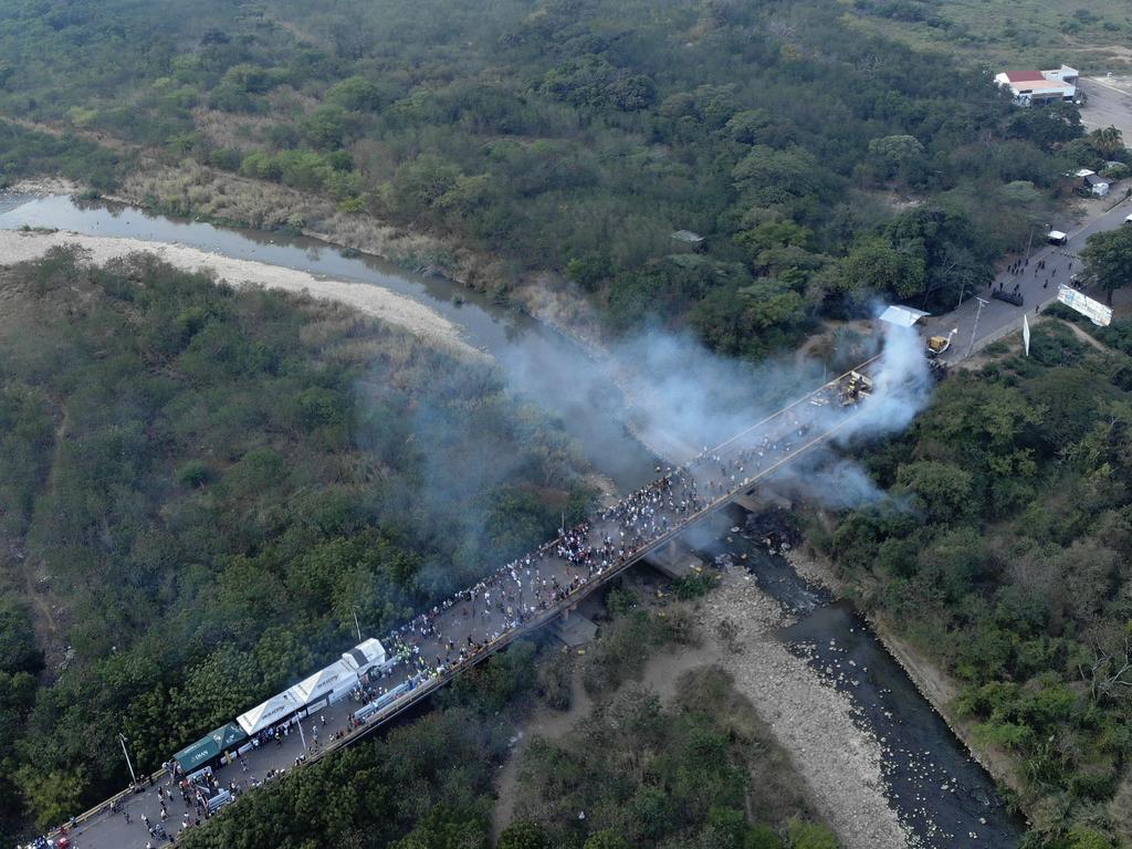 Aerial picture showing demonstrators and smoke billowing from trucks which were carrying humanitarian aid and which were set ablaze on the Francisco de Paula Santander International Brige between Cucuta in Colombia and Urena in Venezuela. Picture: AFP