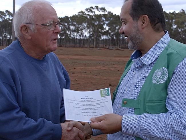 Farmer Rusty Mitchell receives a voucher from Human Appeal team chairman Riyad Qasim.