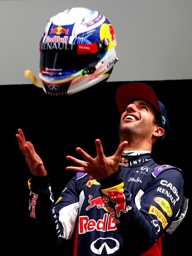 Daniel Ricciardo of Australia and Infiniti Red Bull Racing throws his helmet in the air as he poses for photographers during previews to the Australian Formula One Grand Prix. Picture: Andrew Hone/Getty Images