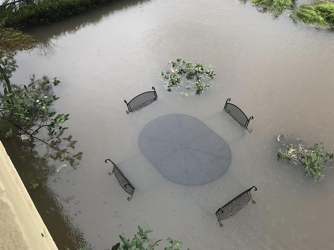 A flooded home at Nelson Bay, where the patio furniture is almost completely under water. Supplied.