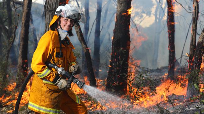 National Parks and Wildlife’s Dani Boddington performs a controlled burn-off at an entry road to Cleland Wildlife Park last week. Picture: Tait Schmaal