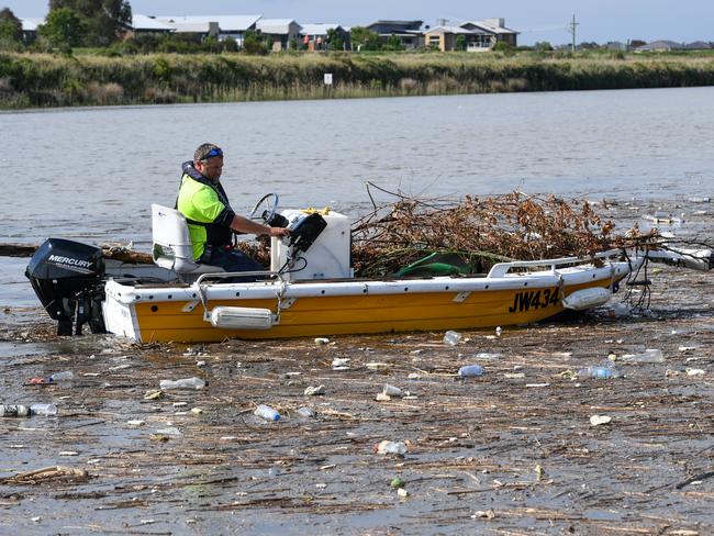 Martin Haggarty from the Patterson Lakes Marina cleans up the rubbish that poured down the Patterson River and into the Marina after heavy rain. PICTURE: PENNY STEPHENS