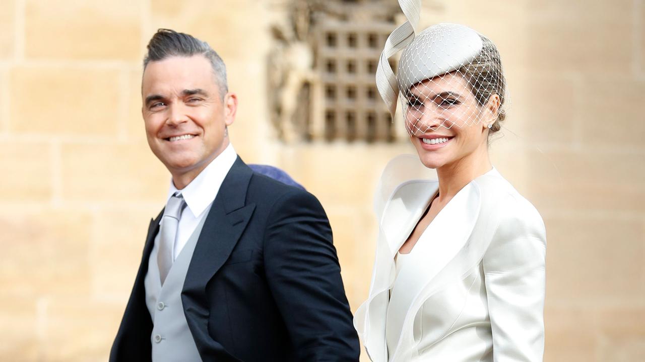 British singer-songwriter Robbie Williams (L) arrives with his wife US actress Ayda Field (R) to attend the wedding of Britain's Princess Eugenie of York to Jack Brooksbank at St George's Chapel, Windsor Castle, in Windsor, on October 12, 2018. (Photo by Alastair Grant / various sources / AFP)