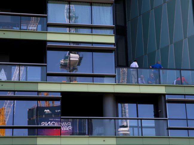 Representatives of the builder inspect Opal Tower before residents were evacuated for the second time. Picture: Toby Zerna