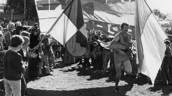 SA footballer Fred Bills leading his West Torrens teammates onto Thebarton Oval for his 312th and last league match against West Adelaide.