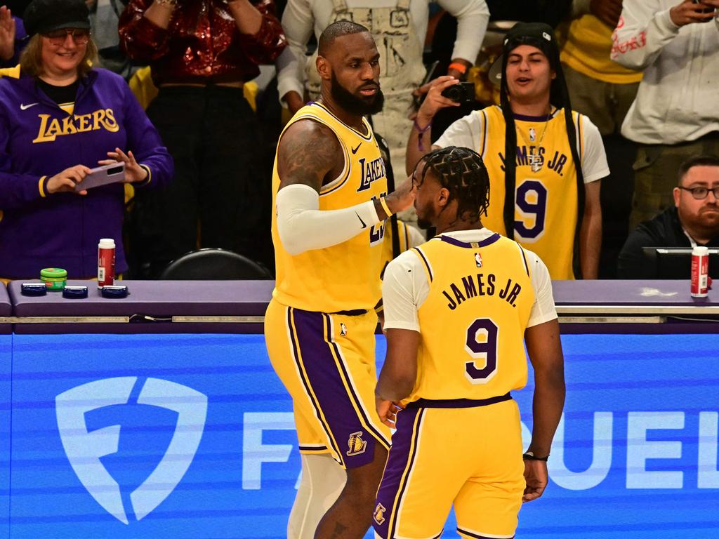 Los Angeles Lakers' US small forward #23 LeBron James (L) and Los Angeles Lakers' US guard #09 Bronny James are seen on court during the NBA game season opener between the Los Angeles Lakers and the Minnesota Timberwolves at Crypto Arena in Los Angeles on October 22, 2024. LeBron and Bronny are the first father and son to play together in any NBA game. (Photo by Frederic J. Brown / AFP)