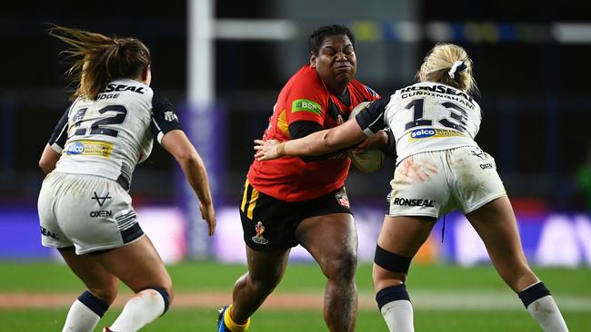 Essay Banu is tackled by Emily Rudge and Jodie Cunningham of England during the Women's Rugby League World Cup. (Photo by Gareth Copley/Getty Images)