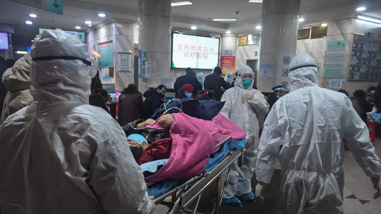 Medical staff wearing protective clothing arrive with a patient at the Wuhan Red Cross Hospital in Wuhan on January 25. Picture: Hector Retamal/AFP