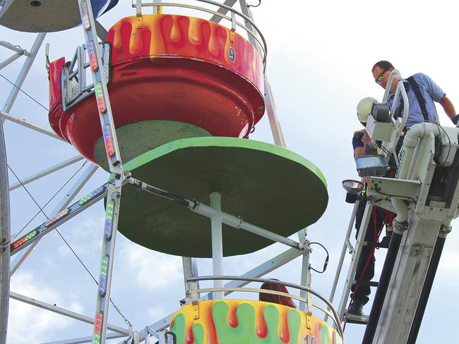 Caney Branch Volunteer Fire Department Chief Ryan Holt stands on the top of a ladder at the Ferris wheel. Picture: Ken Little/Greeneville Sun via AP