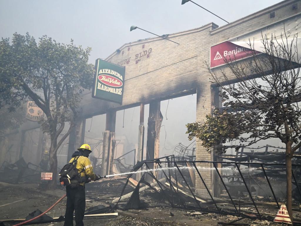 AFTER: A firefighter extinguishes the remains of a hardware store destroyed in the Eaton fire in Altadena, California, on January 8. Picture: AFP via Getty Images