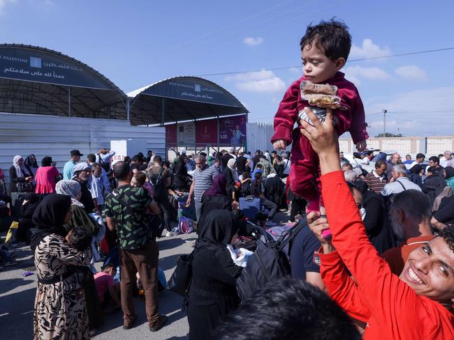 Palestinians, some with foreign passports hoping to cross into Egypt and others waiting for aid wait at the Rafah crossing in the southern Gaza Strip. Picture: AFP