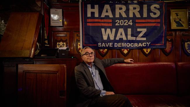 A patron sits beneath a Kamala Harris election flag as he watches coverage of the US presidential election.