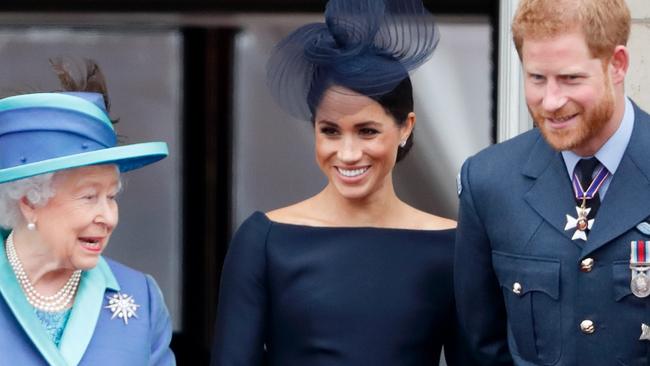 LONDON, UNITED KINGDOM - JULY 10: (EMBARGOED FOR PUBLICATION IN UK NEWSPAPERS UNTIL 24 HOURS AFTER CREATE DATE AND TIME) Queen Elizabeth II, Meghan, Duchess of Sussex and Prince Harry, Duke of Sussex watch a flypast to mark the centenary of the Royal Air Force from the balcony of Buckingham Palace on July 10, 2018 in London, England. The 100th birthday of the RAF, which was founded on on 1 April 1918, was marked with a centenary parade with the presentation of a new Queen's Colour and flypast of 100 aircraft over Buckingham Palace. (Photo by Max Mumby/Indigo/Getty Images)