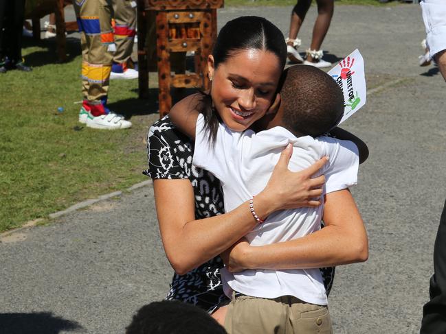 Hugging a tiny wellwisher. Picture: Ian Vogler — Pool/Getty Images.