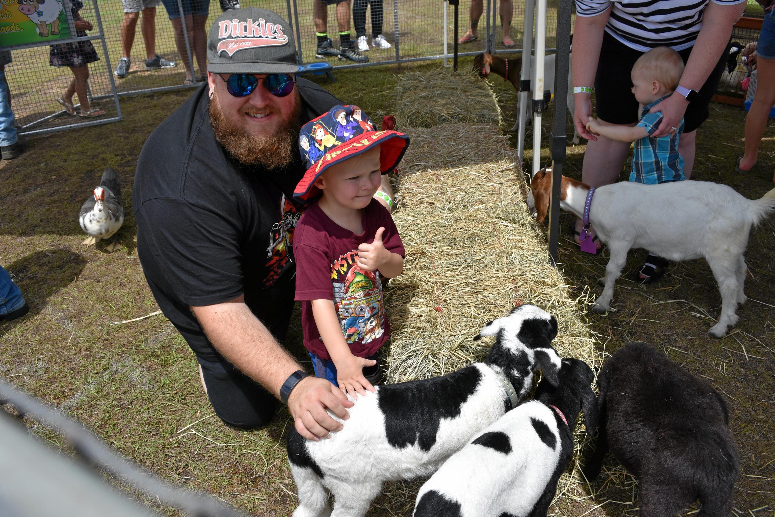 Danny Schaufler and Vance Shaufler, 3, make a friend in the animal nursery at Matty Hillcoat's Day Out. Picture: Arthur Gorrie