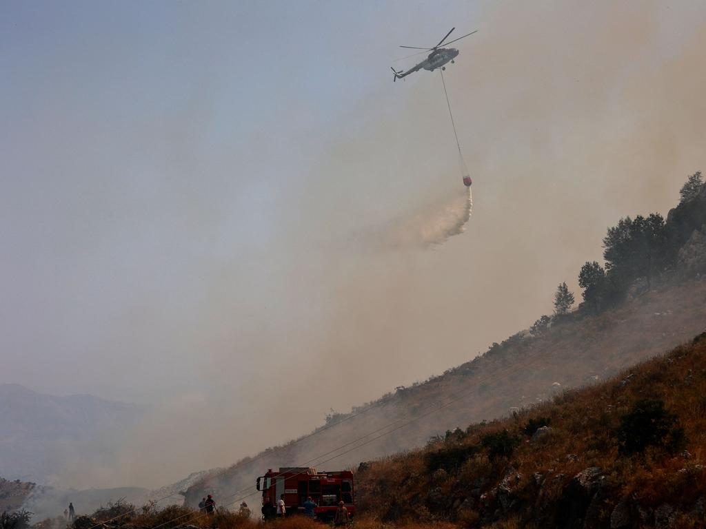 A helicopter drops water over fires in the northern part of the Greek island of Corfu as evacuations are underway. Picture: AFP