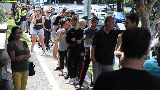 Lines of people wait at Southport Centrelink. Pics Adam Head