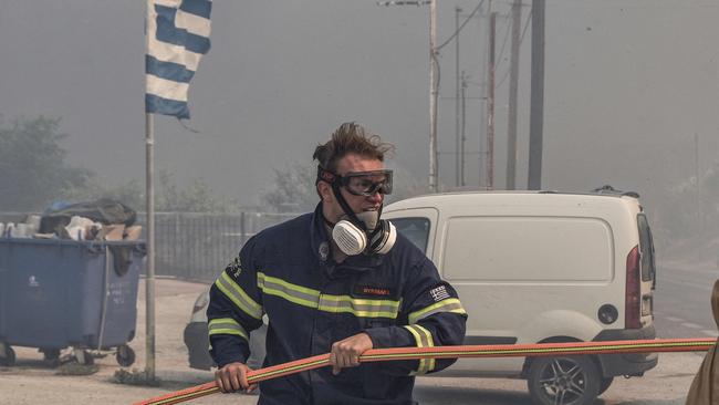 Firefighters try to put out a wildfire 50km southeast from the centre of Athens. Picture: AFP