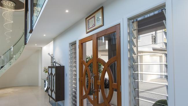 The chandelier lighting up the curved staircase at the entrance to 10 Ocean Vista Lane, Buderim. Picture: Tracy Boldery – Lamina Photography.