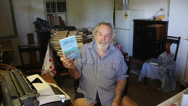 Author Richie Britten holds up the second edition of his book Around the Cassowary Rock. Picture: Peter Carruthers