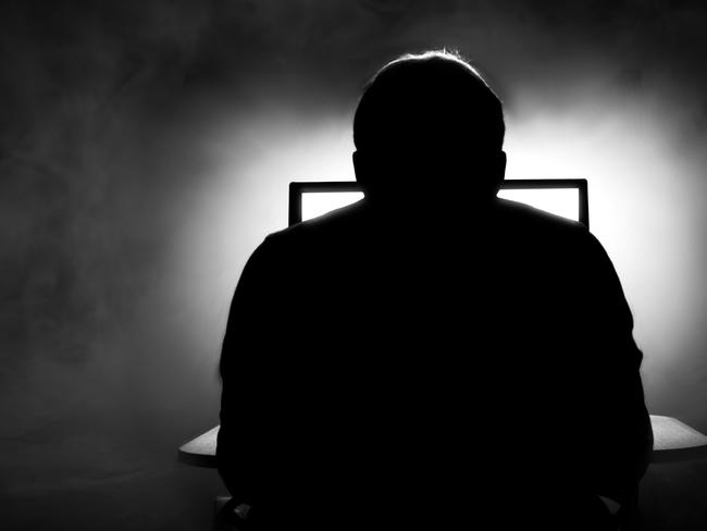 Man in front of computer. Dark night room with smoke. Man on computer. Sillhouette. Internet dating. From behind. iStock-862022082.jpg Photo: iStock